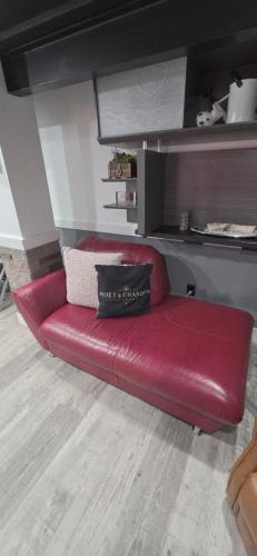 a red couch with a pillow on top of it at Staycation Oasis! a unique Experience! Heated pool open until October 31st in Easton