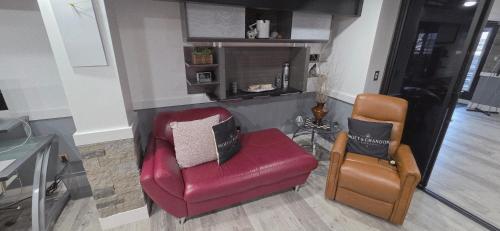 a living room with a red chair and a tv at Staycation Oasis! a unique Experience! Heated pool open until October 31st in Easton