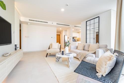 a living room with a couch and a tv at Groups and Families Paradise - 5 min from ADGM, Galleria, Cleveland, Beach, etc - Designer's Choice - New Building - Heart of Al Reem in Abu Dhabi