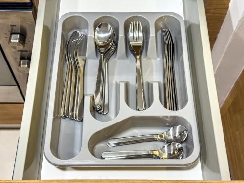 a drawer filled with silver utensils in a kitchen at Groups and Families Paradise - 5 min from ADGM, Galleria, Cleveland, Beach, etc - Designer's Choice - New Building - Heart of Al Reem in Abu Dhabi