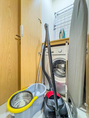 a mop sitting next to a washing machine at Groups and Families Paradise - 5 min from ADGM, Galleria, Cleveland, Beach, etc - Designer's Choice - New Building - Heart of Al Reem in Abu Dhabi