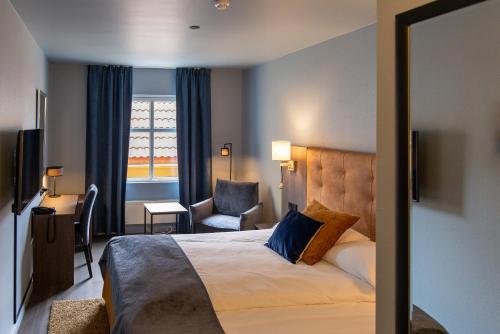 a hotel room with a bed and a chair at Quality Hotel Florø in Florø