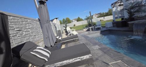 a swimming pool with a bench next to a building at Staycation Oasis! a unique Experience! Heated pool open until October 31st in Easton