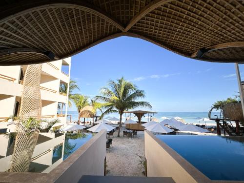 a view of a resort with a swimming pool and the ocean at Ana y Jose Hotel & Beach Club Holbox in Holbox Island