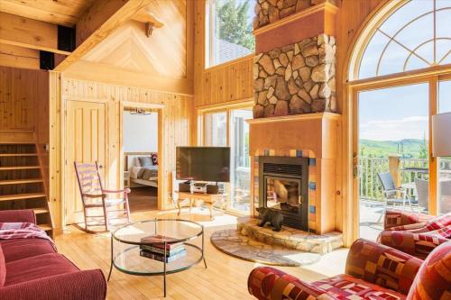 a living room with a fireplace and a tv at Le Chalet Orange in Shawinigan
