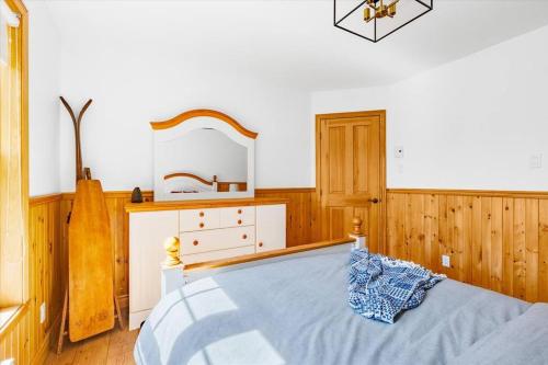 a bedroom with a bed and a dresser and a mirror at Le Chalet Orange in Shawinigan