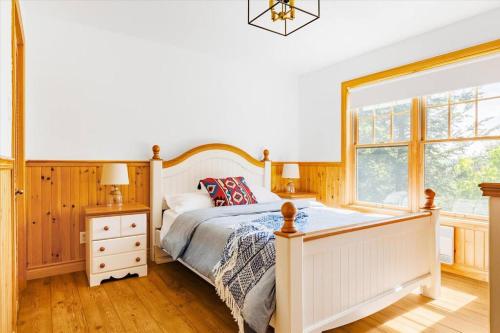 a bedroom with a white bed and a window at Le Chalet Orange in Shawinigan