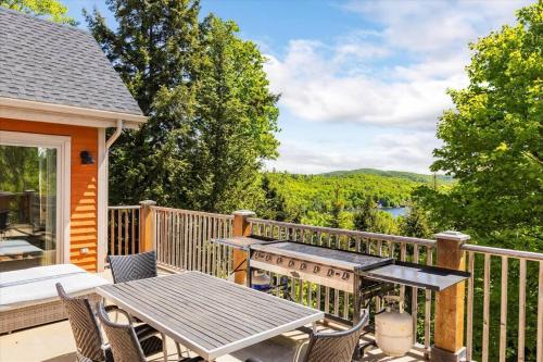 a patio with a table and chairs on a deck at Le Chalet Orange in Shawinigan