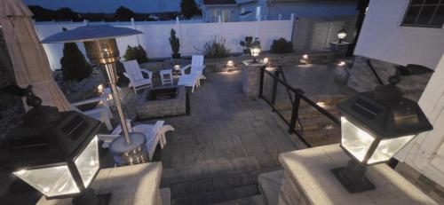 an outdoor patio with white chairs and an umbrella at Staycation Oasis! a unique Experience! Heated pool open until October 31st in Easton