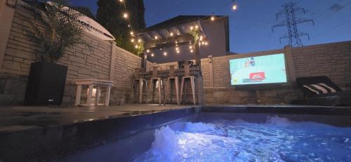 a swimming pool in front of a building with a tv at Staycation Oasis! a unique Experience! Heated pool open until October 31st in Easton