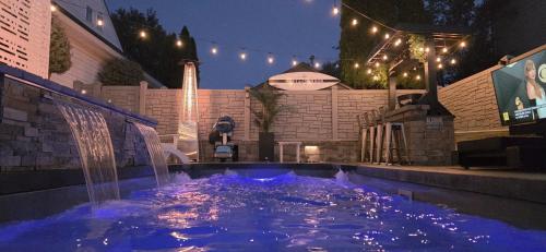 a swimming pool with a water fountain at night at Staycation Oasis! a unique Experience! Heated pool open until October 31st in Easton