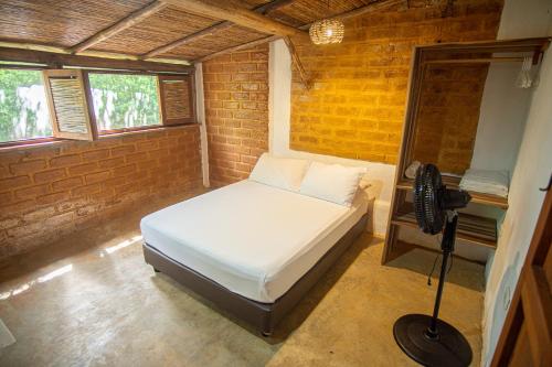 a bedroom with a bed in a brick wall at Hotel Victoria Barichara in Barichara