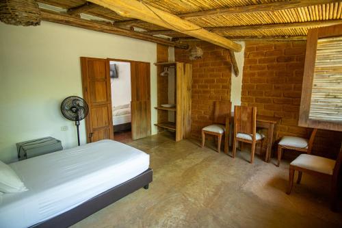 a bedroom with a bed and a table and chairs at Hotel Victoria Barichara in Barichara