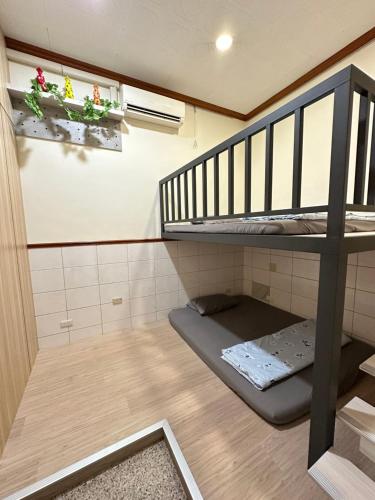 a small room with a bunk bed and a staircase at HJ Station in Lu-feng