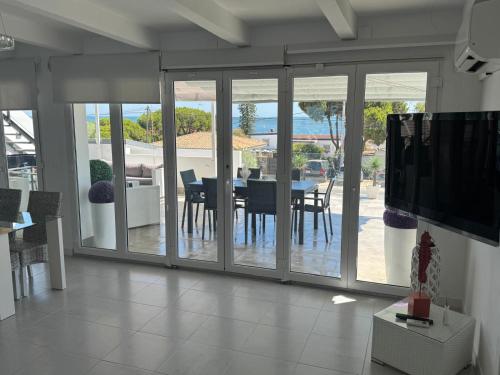 a living room with sliding glass doors with a dining table at Casa Mazagón con vistas al mar in Mazagón