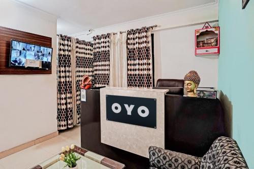 a room with a tv and a person sitting at a desk at Super Hotel O Golden Imperial in Noida