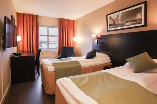 a hotel room with two beds and a window at Quality Hotel Florø in Florø