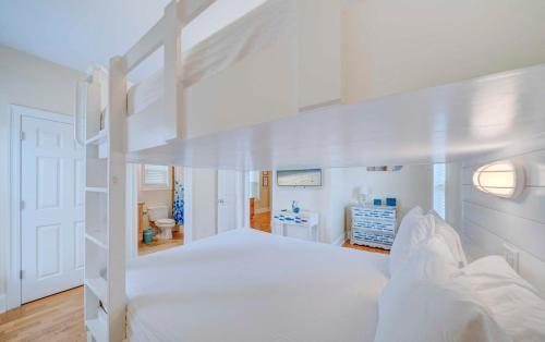 ein Schlafzimmer mit einem weißen Etagenbett und ein Badezimmer in der Unterkunft Holiday Beach at Thomas Drive in Panama City Beach