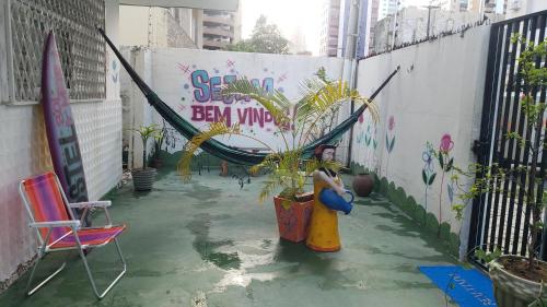 a patio with a plant and a hammock and a chair at Pousada e Hostel Sol e Mar in João Pessoa