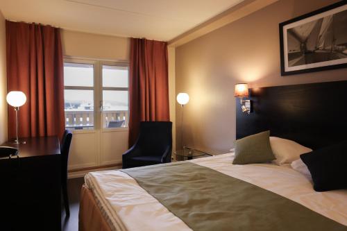 a hotel room with a bed and a desk and a window at Quality Hotel Florø in Florø