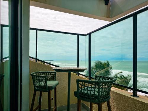 a balcony with a table and chairs and the ocean at Rudá Boutique Hotel Porto de Galinhas in Porto De Galinhas
