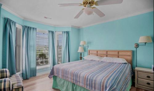 Un dormitorio con una cama y un ventilador de techo. en Beach Dream, en Holden Beach