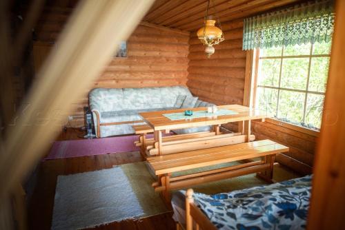 ein Wohnzimmer mit Tisch und Couch in der Unterkunft Putkola Cottage Finland in Virasoja