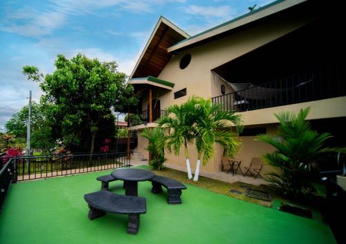 a house with a bench on a green yard at Blu House Nature & Tours in Chachagua