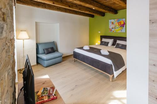 a bedroom with a bed and a chair and a television at Villa Sofija in Kojsko