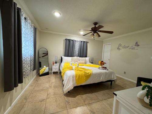 a bedroom with a bed with yellow sheets and a ceiling fan at Sunshine Nest in Lehigh Acres