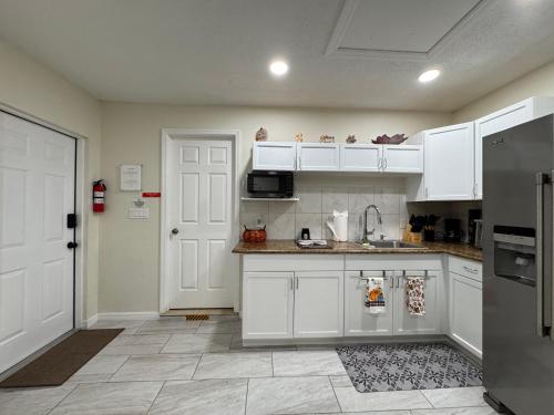a kitchen with white cabinets and a refrigerator at Sunshine Nest in Lehigh Acres