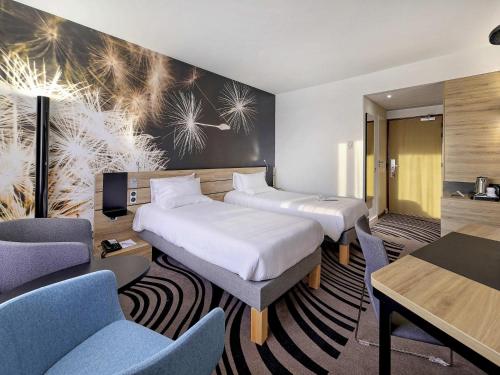 a hotel room with two beds and chairs at Novotel Katowice Centrum in Katowice