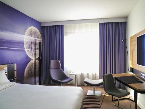 a hotel room with a bed and a desk at Novotel Katowice Centrum in Katowice