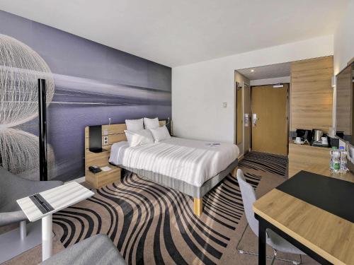 a hotel room with a bed and a desk at Novotel Katowice Centrum in Katowice