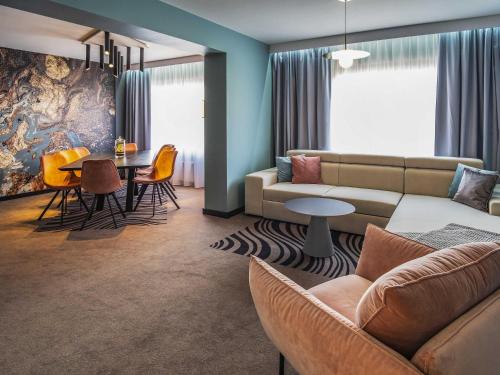 a living room with a couch and a table at Novotel Katowice Centrum in Katowice