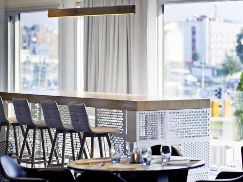 a restaurant with tables and chairs in front of a window at Novotel Katowice Centrum in Katowice