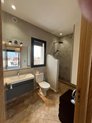 a bathroom with a toilet and a tub and a sink at Dar'S in Moulay Douraïne