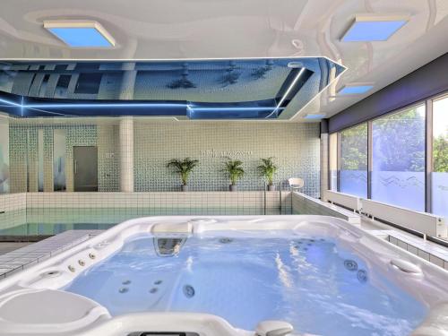 a large bath tub in a room with windows at Novotel Katowice Centrum in Katowice
