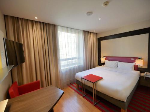a hotel room with a bed and a table and a desk at Mercure Warszawa Grand in Warsaw