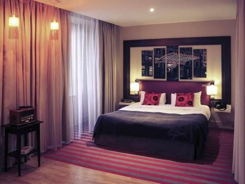 a bedroom with a large bed with red pillows at Mercure Warszawa Grand in Warsaw