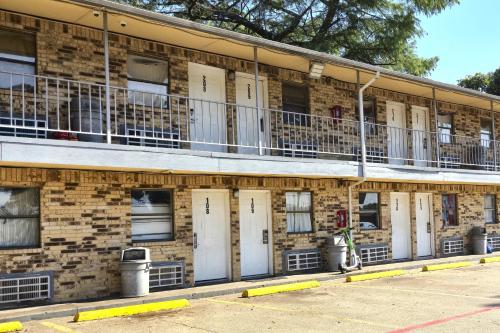 a brick building with white doors and balconies at Mi Amor Inn & Suites by Hotel O Dallas Tx Hwy 352 in Dallas