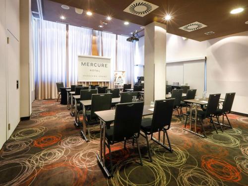 a group of tables and chairs in a room at Mercure Warszawa Grand in Warsaw