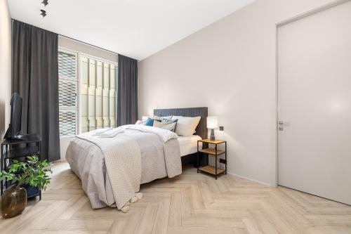 レイキャビクにあるMost Desirable Penthouse in Reykjavíkのベッドと大きな窓のある白い寝室