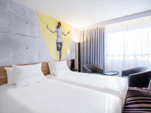 a hotel room with two beds and a painting on the wall at Novotel Warszawa Centrum in Warsaw