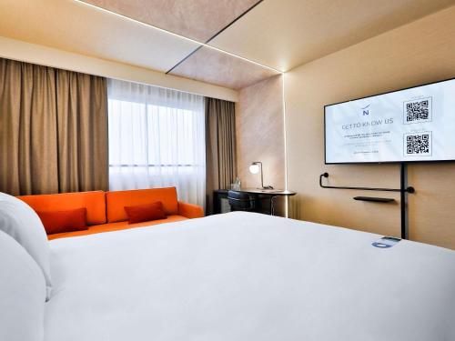 a hotel room with a bed and a tv at Novotel Warszawa Centrum in Warsaw