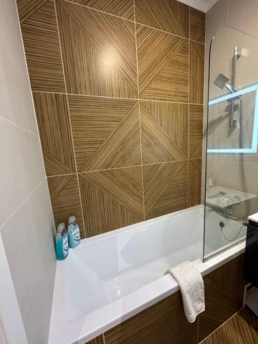 a bathroom with a tub and a wooden wall at Loft Aparts in Chişinău