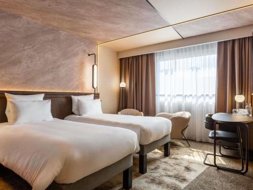a hotel room with two beds and a window at Novotel Warszawa Centrum in Warsaw