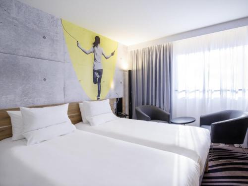 a hotel room with two beds and a painting on the wall at Novotel Warszawa Centrum in Warsaw