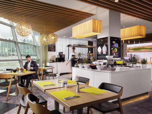a man sitting at tables in a restaurant at Novotel Warszawa Centrum in Warsaw