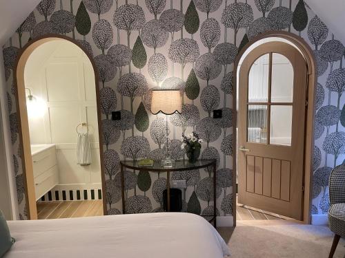 a bedroom with a bed and a table and a door at The Red Lion in Blewbury